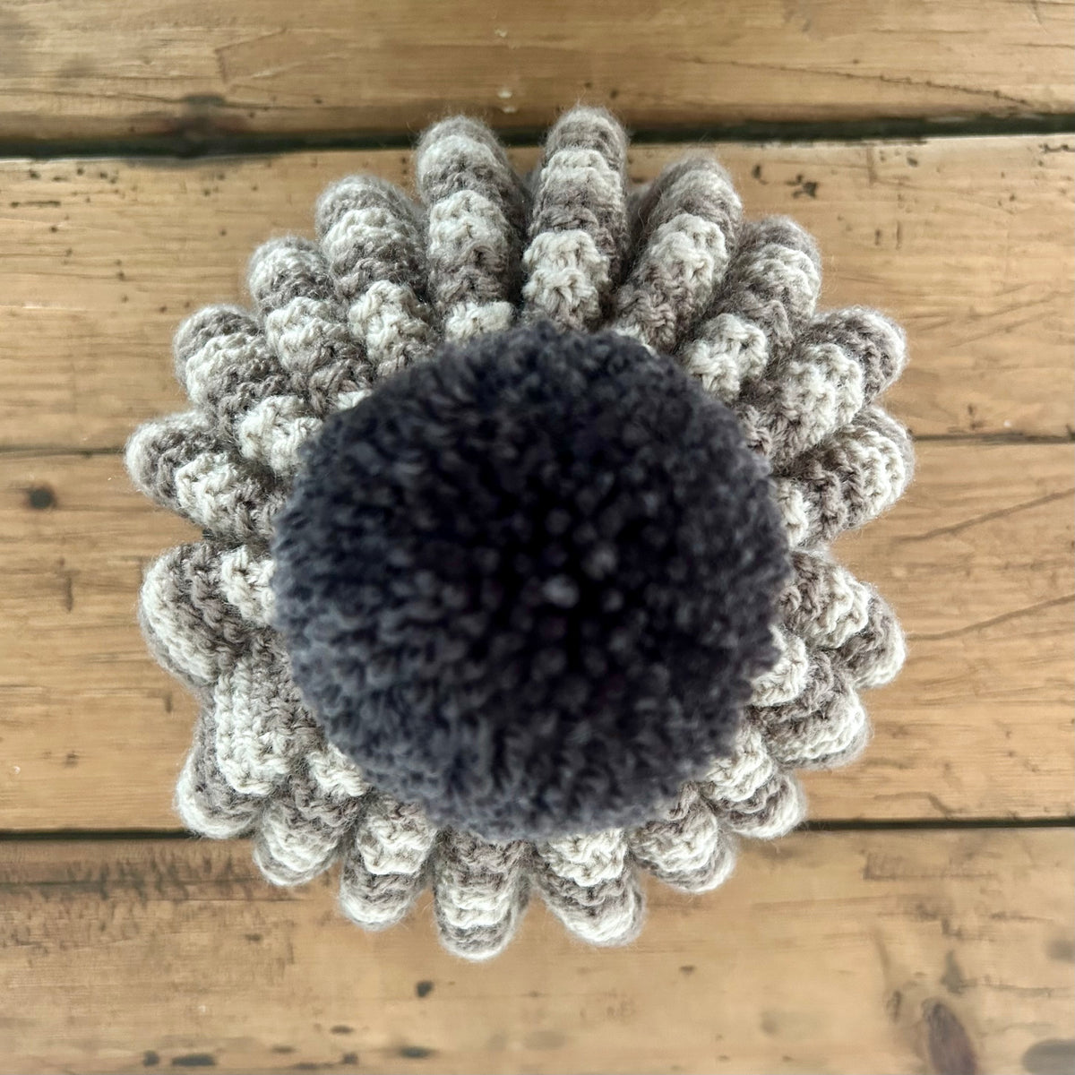 a close up of a pom pom on a handknitted tea cosy